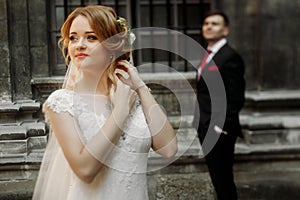 Beautiful blonde bride in luxury white wedding dress posing outdoors in italian street, face closeup of gorgeous newlywed