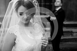 Beautiful blonde bride in luxury white wedding dress posing outdoors in italian street, face closeup of gorgeous newlywed