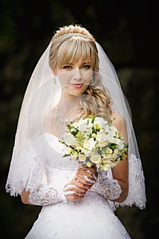 Beautiful blonde bride with wedding bouqet in the hands