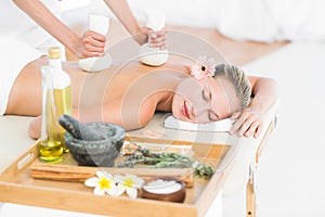 Beautiful blonde enjoying a herbal compress massage