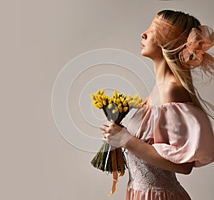 Beautiful blonde fashion woman with closed eyes and bouquet of artificial stabilized yellow flowers for home