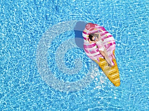 A beautiful, blonde girl enjoys a hot summer day in the pool