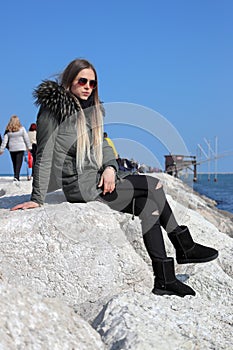 Beautiful blonde girl, model, walks near the sea. La Diga, Veneto, Italy.