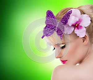 Beautiful blonde girl with orchid flower and butterfly