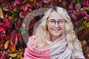 A beautiful blonde girl in a pink coat walks in the Park