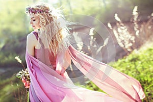 Beautiful blonde girl in pink long dress