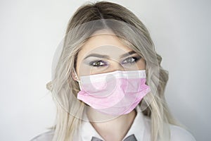 Beautiful blonde girl put on a protective pink mask