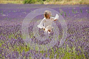 Beautiful blonde girl runs through a lavender field