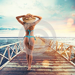 Beautiful blonde girl in swimsuit on a pier