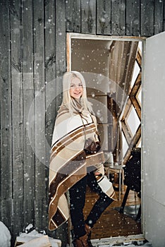 Beautiful blonde girl with a vintage camera smiling on a wooden wall background