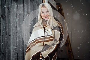 Beautiful blonde girl with a vintage camera smiling on a wooden wall background