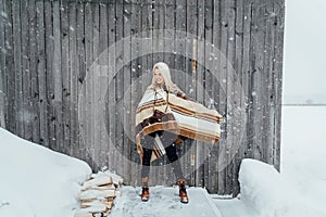 Beautiful blonde girl with a vintage camera smiling on a wooden wall background