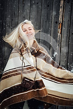 Beautiful blonde girl with a vintage camera smiling on a wooden wall background