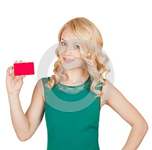 Beautiful blonde in a green dress holds a card