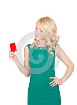 Beautiful blonde in a green dress holds a card