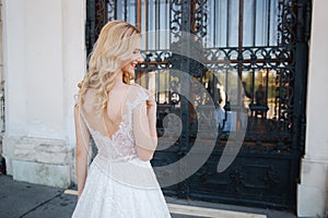 Beautiful blonde hair bride near the pacale. Women in an elegant white wedding dress