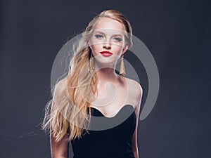 Beautiful blonde hair woman classic style with red lips and eyarrings and evening dress female portrait