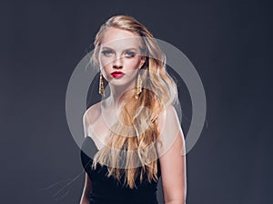 Beautiful blonde hair woman classic style with red lips and eyarrings and evening dress female portrait