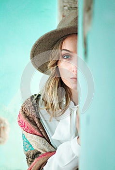 A beautiful blonde-haired girl with a hat between the walls