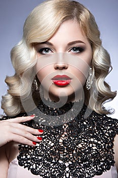 Beautiful blonde in a Hollywood manner with curls, red lips and lace dress. Beauty face.
