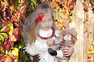 Beautiful blonde little girl with doll