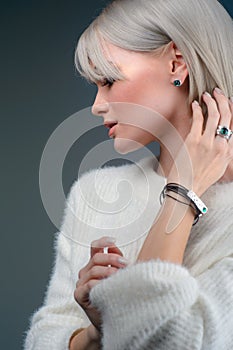 Beautiful blonde with luxurious silver jewelry. Woman wears silver jewelry