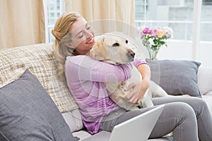 Beautiful blonde relaxing on the couch with pet dog