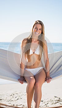 Beautiful blonde sitting on hammock and smiling