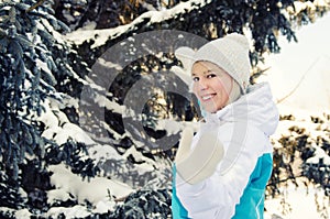 A beautiful blonde girl happily dances amidst the fir trees