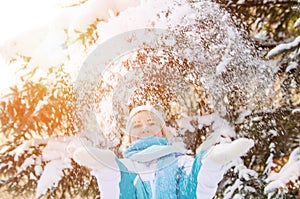 Beautiful blonde smiling girl throws up the snow that beautifull