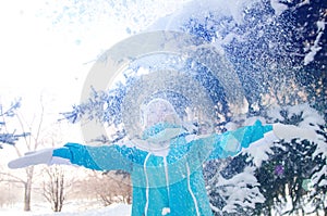 Beautiful blonde smiling girl throws up the snow