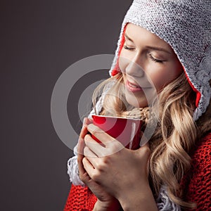 Beautiful blonde woman with an aromatic hot coffee in hands.