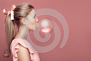 Beautiful blonde woman blowing gum. Fashion portrait