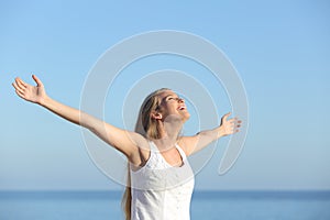 Beautiful blonde woman breathing happy with raised arms