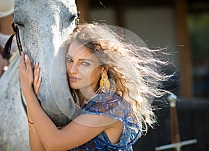 Beautiful blonde woman with curly hair and horse.