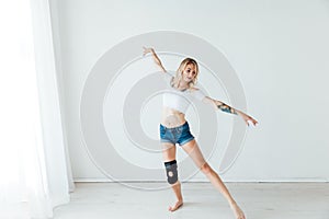 beautiful blonde woman dancing to music in training