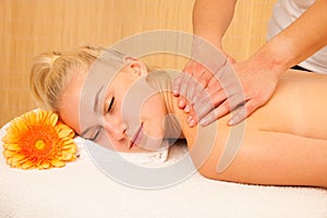 Beautiful blonde woman enyoing massage treatment in sap salon