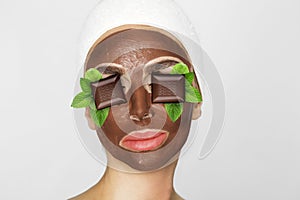Beautiful blonde woman with a facial mask, beauty spa.Chocolate face mask