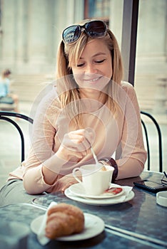 Beautiful blonde woman having breakfast at the bar