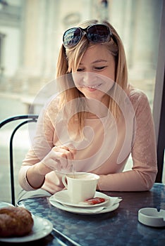 Beautiful blonde woman having breakfast at the bar