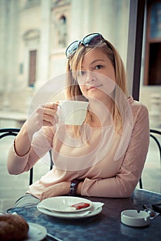 Beautiful blonde woman having breakfast at the bar