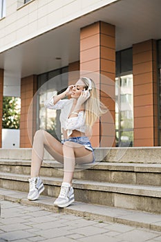 Beautiful blonde woman in headphones listing to music