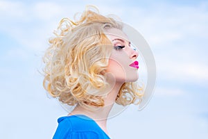 Beautiful blonde woman with healthy skin curly hair and beauty eyes and red lips. Beautiful woman face. Perfect make up.