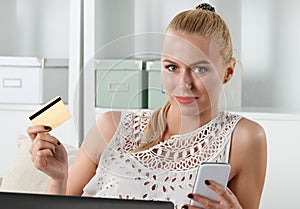 Beautiful blonde woman holding golden credit