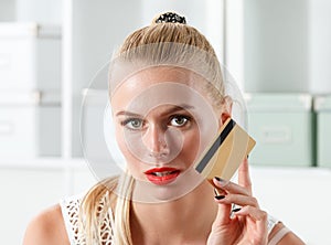 Beautiful blonde woman holding golden credit card