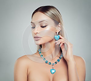 Beautiful Blonde Woman in Jewelry Necklace and Earrings with Diamonds and Turquoise Gem, Fashion Beauty Portrait. Makeup and