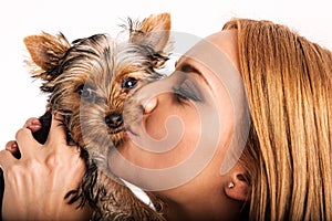 Beautiful blonde woman kissing yorkshire terrier - close up