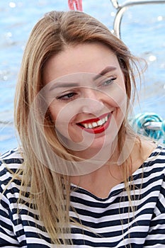 Beautiful blonde woman laughs and having fun on vacation, in stripped t-short . Summer.