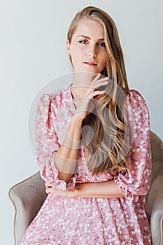 beautiful blonde woman in a light summer pink dress