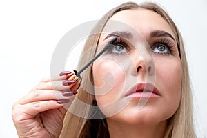 Beautiful blonde woman paints eyelashes. Beautiful female face. Makeup Read More Beauty girl with perfect skin. Makeup